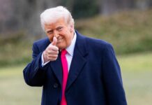 Trump’s PURGE Targets Weak Republicans A man in a dark coat and pink tie giving a thumbs up outdoors