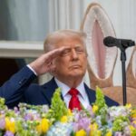 Iran Deal Draft: Can Trump Achieve the Unthinkable? A man in a suit saluting in front of a floral display during an Easter event