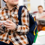 Your Son May Be Dating an AI Right Now — Schools Are Sounding the Alarm Child with smartphone and backpack sitting in classroom