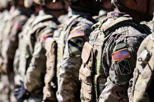 us-military_2321207565-1 Soldiers in camouflage with American flag patches standing