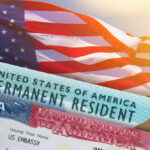Major Green Card Overhaul Could Force Applicants to Leave U.S. Mid-Process U.S. flag with visa and permanent resident card in foreground