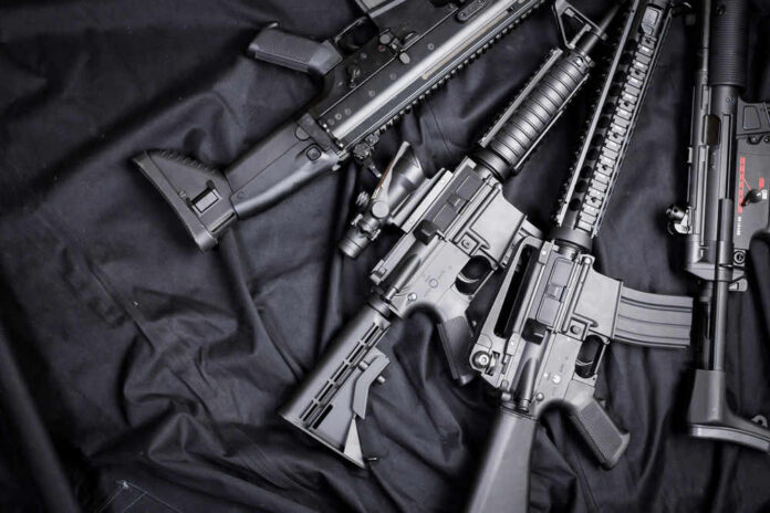 weapon146886211 Black rifles on a dark fabric background