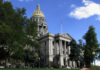 Historic building with dome and American flag outside.