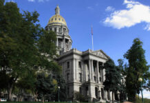 Historic building with dome and American flag outside.