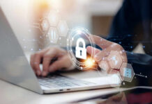 Warrant‑Lite Dragnet Creeps Into Canada Person typing on laptop with digital security icons overlay.