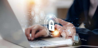 Person typing on laptop with digital security icons overlay.