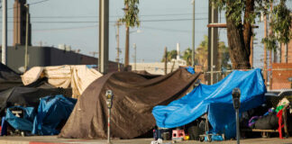 Street encampment with tarps and makeshift shelters