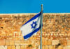 France Backstabs Israel, Lion Takes Flight Israeli flag waving in front of an ancient stone wall