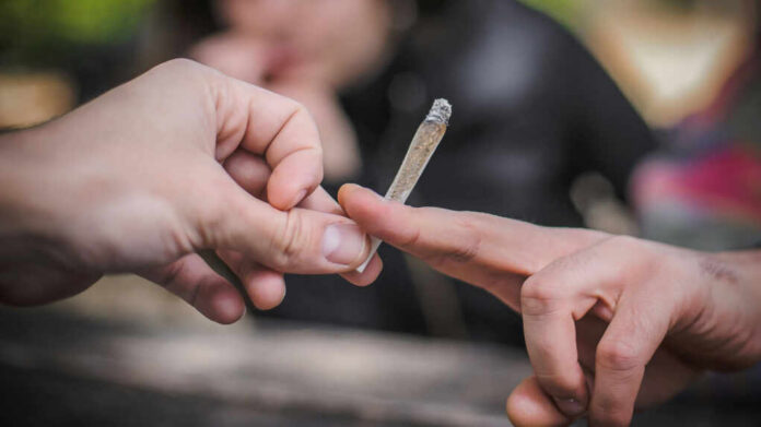 marijuana-joint-hand-to-hand2081447896jpg Hands passing a lit joint between people
