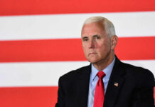Finish It — Pence Slams ‘Paper Peace’ man in suit with red tie in front of red and white stripes