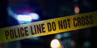 Police tape with do not cross message at night