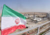 Nukes Deferred—Cash Pipeline Fast-Tracked Iranian flag waving in front of an oil processing facility