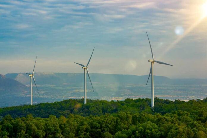 Wind,Turbine,Farm,Concetp,,Windmill,Or,Wind,Turbine,On,Hill Three wind turbines on a green hillside under a cloudy sky