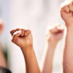 Multiple raised fists in a show of solidarity during a protest