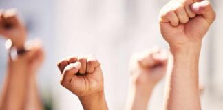 Multiple raised fists in a show of solidarity during a protest
