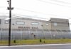 Detention facility behind barbed-wire fence along a street