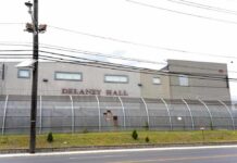 Detention facility behind barbed-wire fence along a street