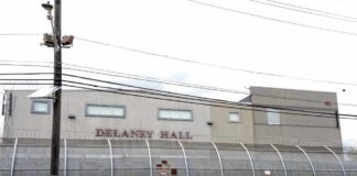 Detention facility behind barbed-wire fence along a street