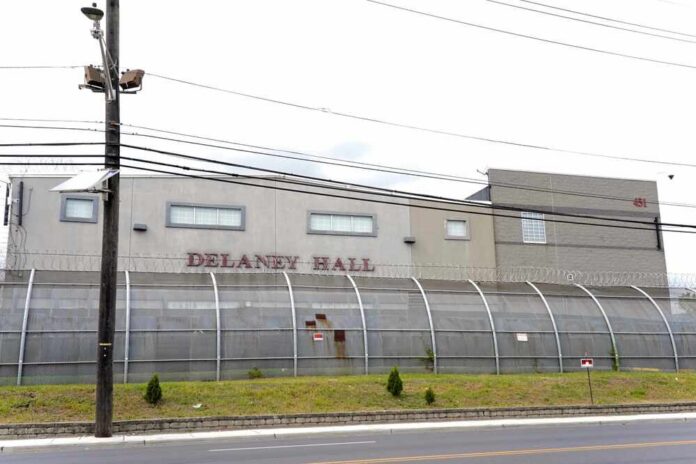 Detention facility behind barbed-wire fence along a street