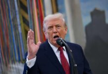 Trump Torpedoes $300B Payout Rumor A man speaking passionately into a microphone with his hand raised