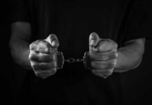 Knife Rampage After Bail Release Hands holding handcuffs in a black and white image