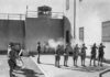 Soldiers executing a prisoner in a military setting