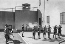 Soldiers executing a prisoner in a military setting