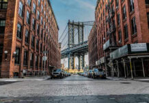 Bridge Debris Horror Triggers $10.5M Payout Street view with bridge between two brick buildings.