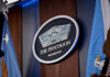 War Powers Meltdown: Who’s Really In Charge? The Pentagon emblem between two flags.