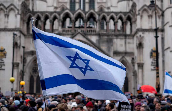 2393485591 Israeli flag at a crowded outdoor event.