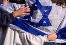 Wartime Spy Flip Inside Israel’s Ranks People holding an Israeli flag together, showcasing unity and cultural pride