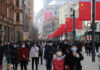 Beijing’s Growth Stalls — Hidden Rot Exposed Crowded street with people wearing masks and flags