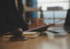 Courts Expose Phantom Cases — Lawyers Burned Judge's gavel on desk with person writing in background