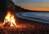Beach bonfire at dusk by the shoreline