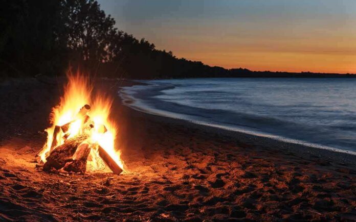shutterstock_1039850923 Beach bonfire at dusk by the shoreline