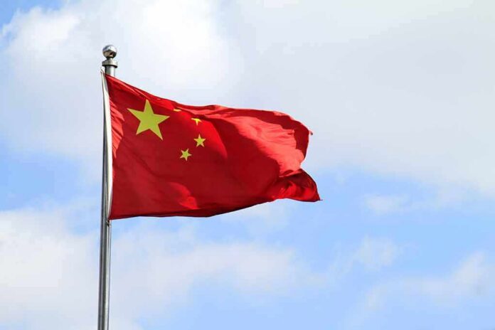 shutterstock_1060497302 Chinese national flag waving on a flagpole