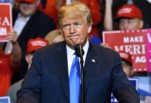 No Blank Checks—New Play Shocks NATO man in suit speaking at a rally podium