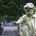 Babysitter’s Deadly Mistake Sparks Florida Fury Weathered angel statue holding a cross in a cemetery