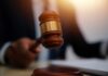 Defamation Firestorm Engulfs Candace Owens A gavel being struck on a desk in a courtroom setting