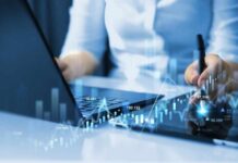Apple-Nvidia Flip Exposes Bubble Nerves Businessperson analyzing stock data on tablet beside laptop