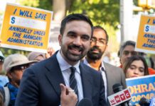 Immigrant Map Sparks Italian-American Backlash A man speaking at a rally with supporters holding protest signs