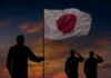 Japan’s Hidden Tank Goes Global Silhouettes of soldiers saluting the Japanese flag against a sunset