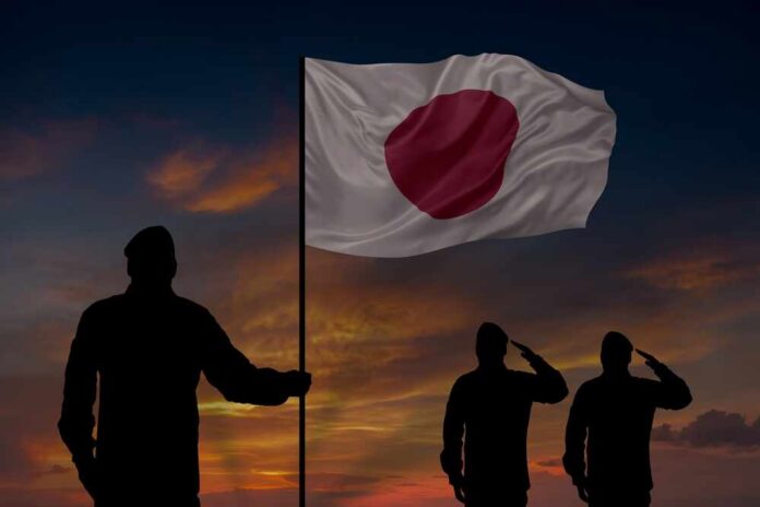 Military,Mans,Holds,In,Their,Hands,National,Flag,In,Honor Silhouettes of soldiers saluting the Japanese flag against a sunset