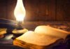 Hidden Journal Targets Unnamed Predators Open antique book beside a glowing oil lamp