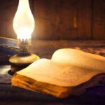 Hidden Journal Targets Unnamed Predators Open antique book beside a glowing oil lamp