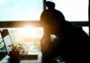 silhouetted person at a desk with head in hands