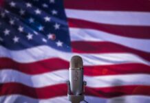 Microphone in front of an American flag backdrop