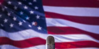 Microphone in front of an American flag backdrop