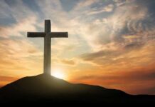 Cross on hill at sunset