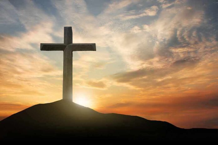 Cross on hill at sunset